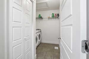 Laundry area featuring washer and dryer and light tile patterned flooring