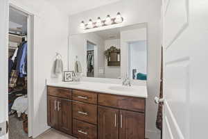 Bathroom with double vanity, a spacious closet, and ensuite bath