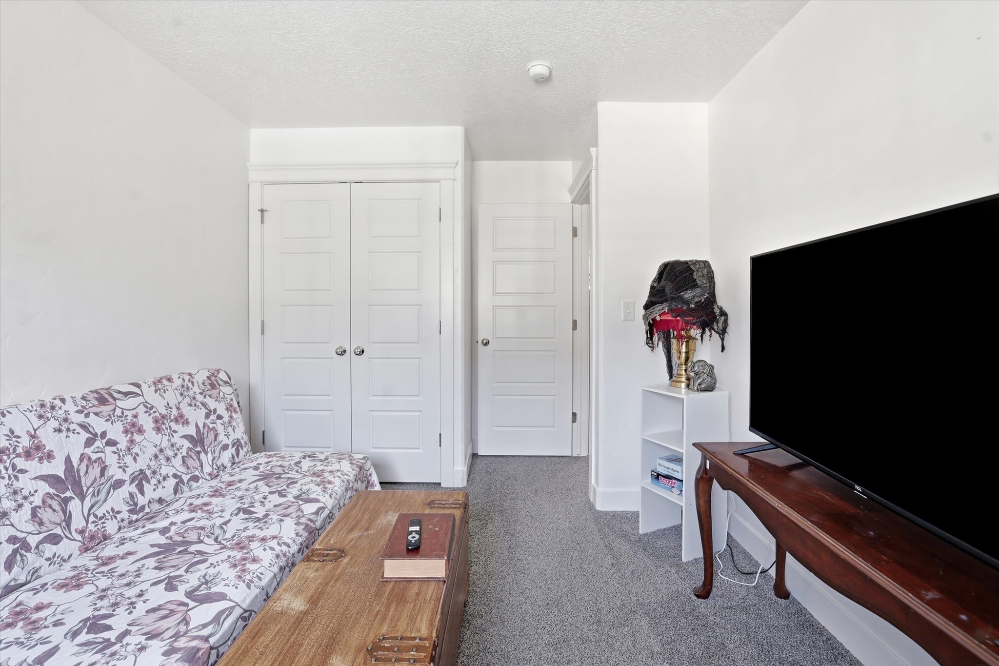 Living room with a textured ceiling and light colored carpet