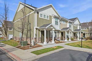 Craftsman-style house featuring board and batten siding, a porch, a residential view, stone siding, and a shingled roof