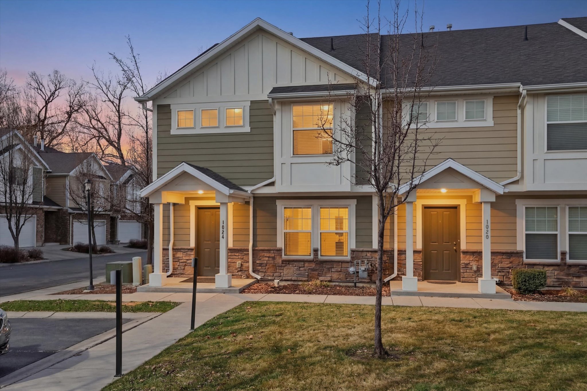 Craftsman inspired home featuring board and batten siding, a front lawn, and stone siding