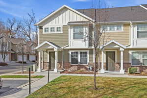 View of front of house featuring board and batten siding, stone siding, and a front lawn