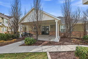 View of front of house featuring a porch, stone siding, and a shingled roof