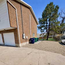 View of property exterior featuring brick siding, driveway, and an attached garage