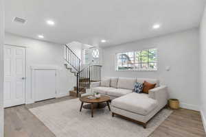 Living area featuring light wood finished floors and recessed lighting