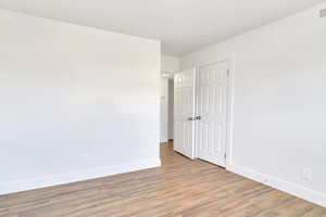 Unfurnished bedroom featuring light wood-style flooring and a closet