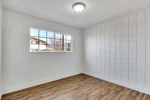 Spare room with tile walls and wood finished floors
