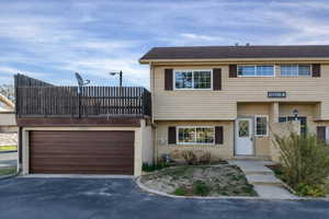 View of front of property featuring brick siding, an attached garage, and asphalt driveway