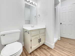 Half bathroom featuring vanity and light wood-type flooring