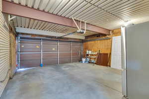 Garage featuring freestanding refrigerator and a garage door opener