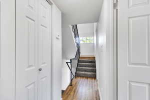 Stairs with wood finished floors and baseboards