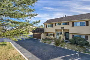 View of front facade featuring brick siding, asphalt driveway, and a garage