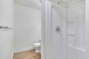 Bathroom featuring light wood-style flooring and a stall shower