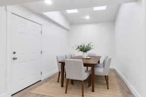 Dining area with light wood-style flooring, recessed lighting, and a skylight