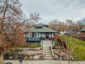Bungalow featuring roof with shingles, covered porch, and brick siding