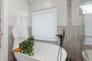 Bathroom with a freestanding bath and tile walls