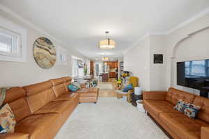 Living room featuring ornamental molding and light wood-type flooring