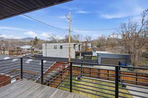 Wooden terrace featuring a residential view, a mountain view, and an outdoor structure