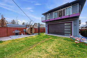 Back of house with a fenced backyard and a balcony