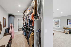 Walk in closet with light colored carpet