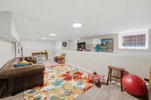 Living area with light carpet and baseboards