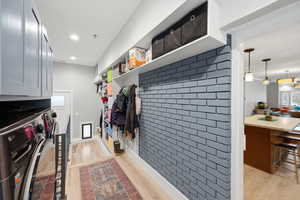 Mudroom with light wood finished floors and independent washer and dryer