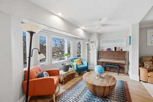 Living area with ceiling fan, light wood-style flooring, and recessed lighting