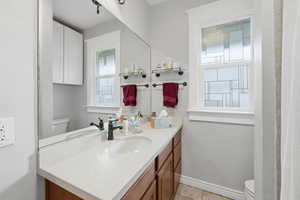 Bathroom featuring vanity, plenty of natural light, and light tile patterned flooring