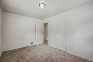 Unfurnished bedroom featuring carpet flooring and baseboards