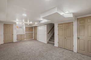 Finished below grade area featuring carpet and stairs