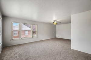 Carpeted empty room featuring ceiling fan and baseboards