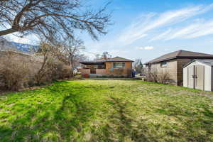 Back of house featuring a shed and a lawn