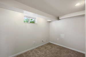 Basement featuring baseboards and carpet flooring