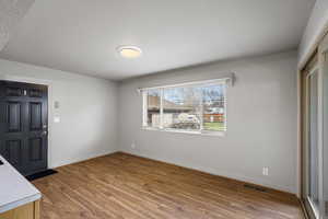 Unfurnished dining area with light wood-style flooring and baseboards