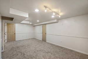 Finished below grade area featuring carpet and track lighting