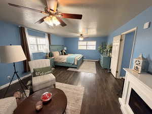 Bedroom with dark wood-style flooring, a textured ceiling, and a ceiling fan