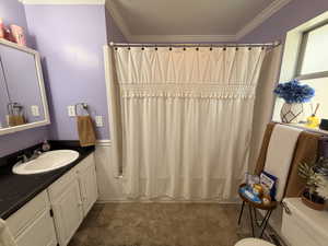 Full bathroom featuring ornamental molding, vanity, shower / bath combo with shower curtain, and a textured ceiling