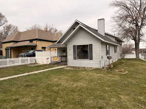 Bungalow featuring a chimney and a shingled roof
