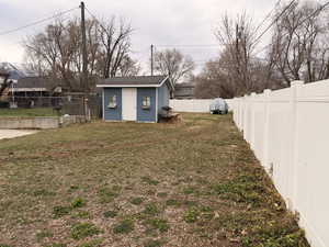 Fenced backyard featuring a storage shed