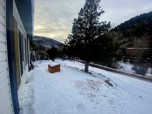 Yard layered in snow with a mountain view
