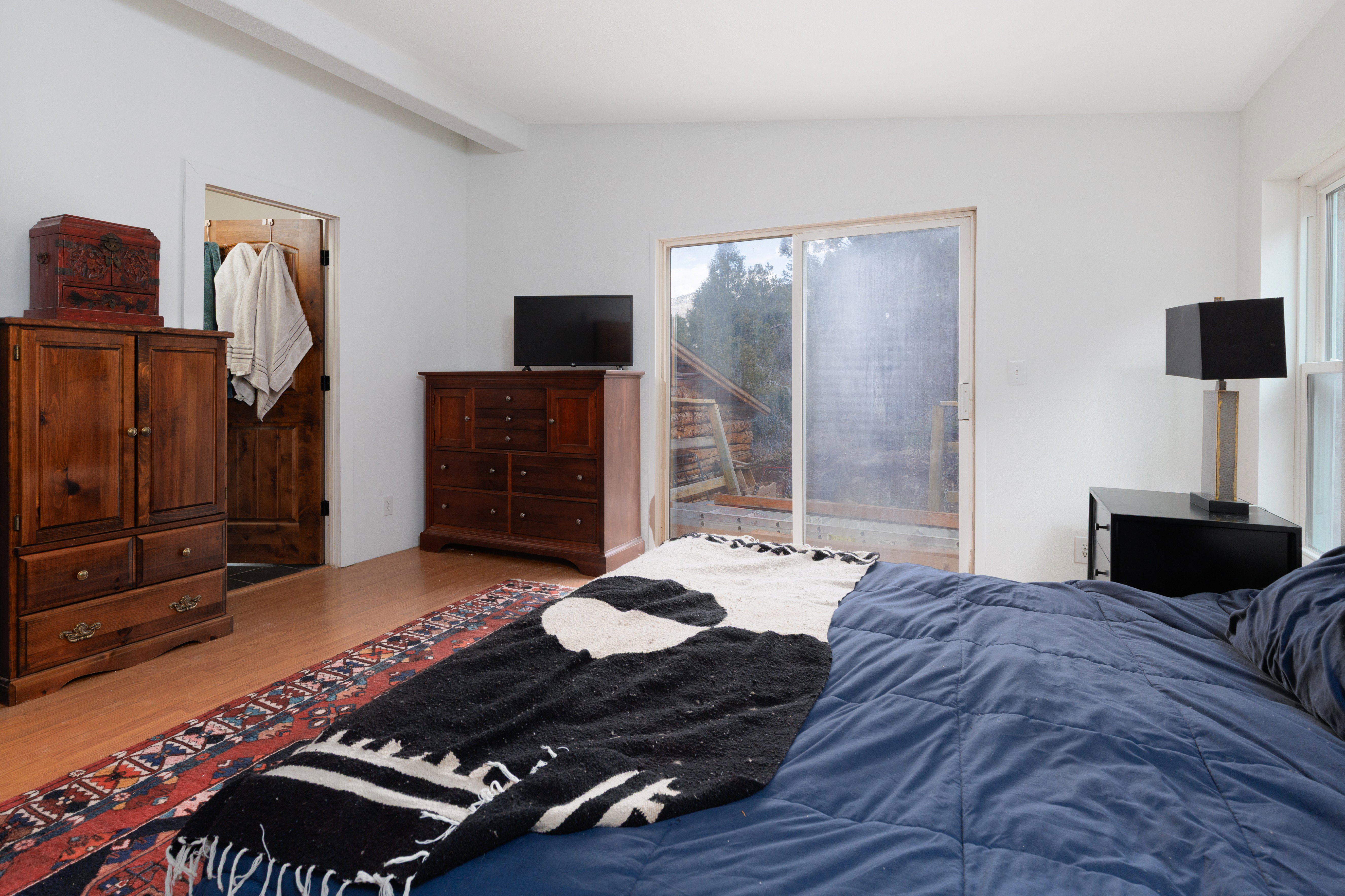 Bedroom with wood-style floors, access to exterior, and vaulted ceiling