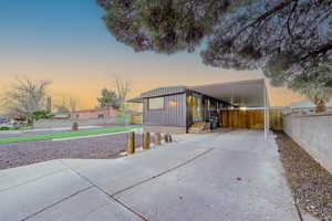Manufactured / mobile home featuring an attached carport, board and batten siding, and driveway