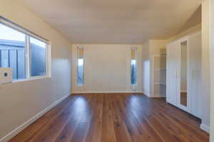 Unfurnished bedroom featuring dark wood-style floors and a closet