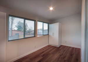 Unfurnished bedroom featuring dark wood-type flooring and a closet
