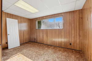 Bedroom featuring paneled walls and a drop ceiling