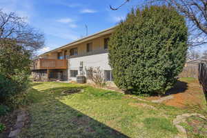 Back of house featuring brick siding and a yard