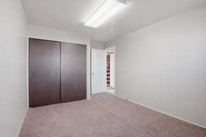 Bedroom featuring light colored carpet and a closet