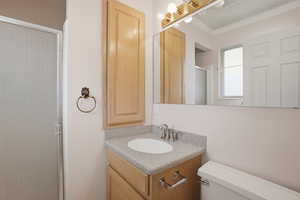 3/4 bath with vanity, crown molding, and a shower stall
