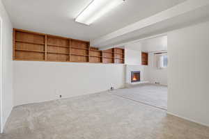 Family room featuring built in features, carpet floors, and a fireplace