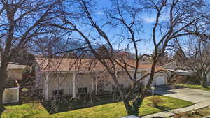 View of front of home with driveway, a front lawn, and a garage